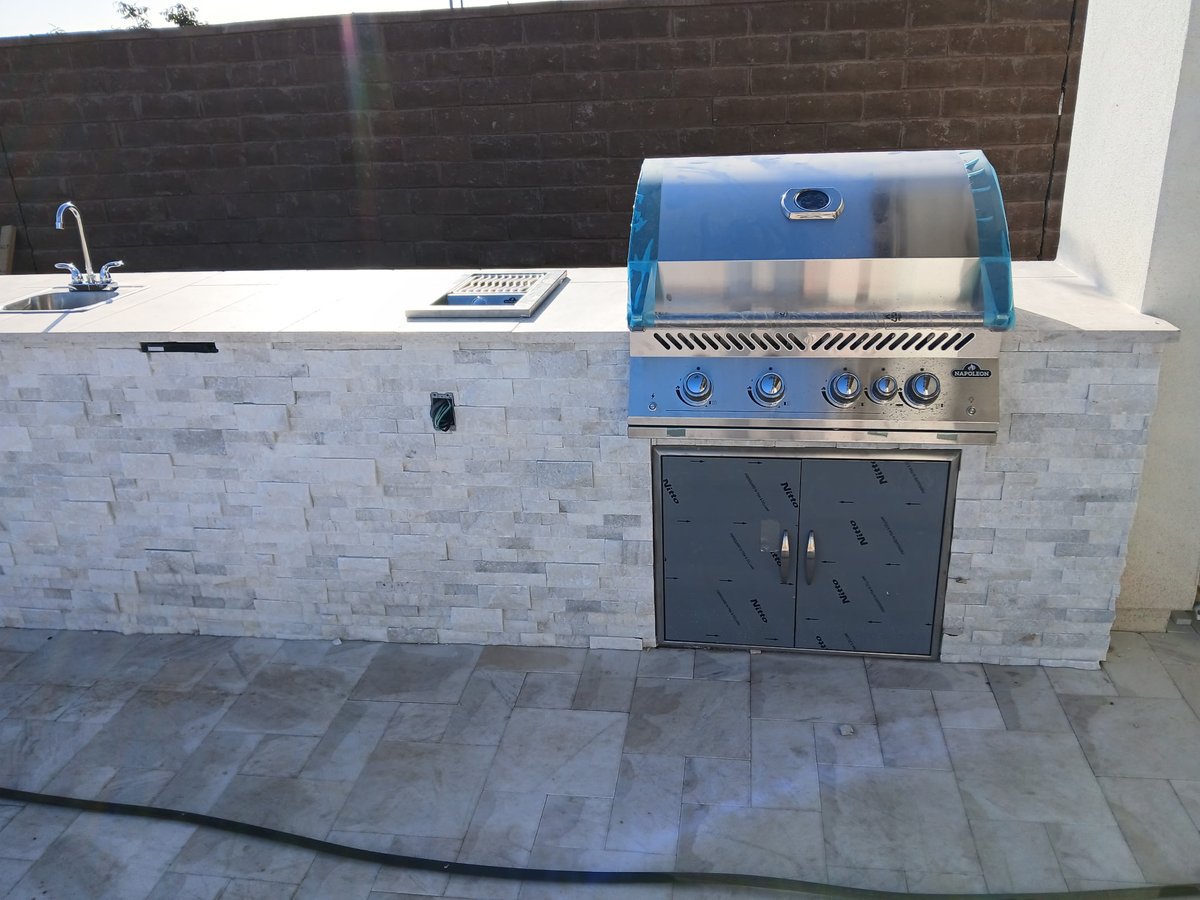 Custom outdoor kitchen with built-in Napoleon grill and stone countertops in Mesa AZ